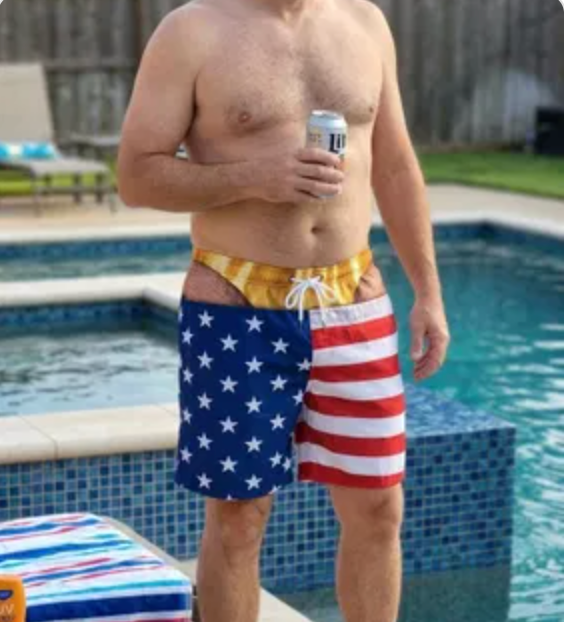 Man standing by the pool wearing flag print swim trunks
